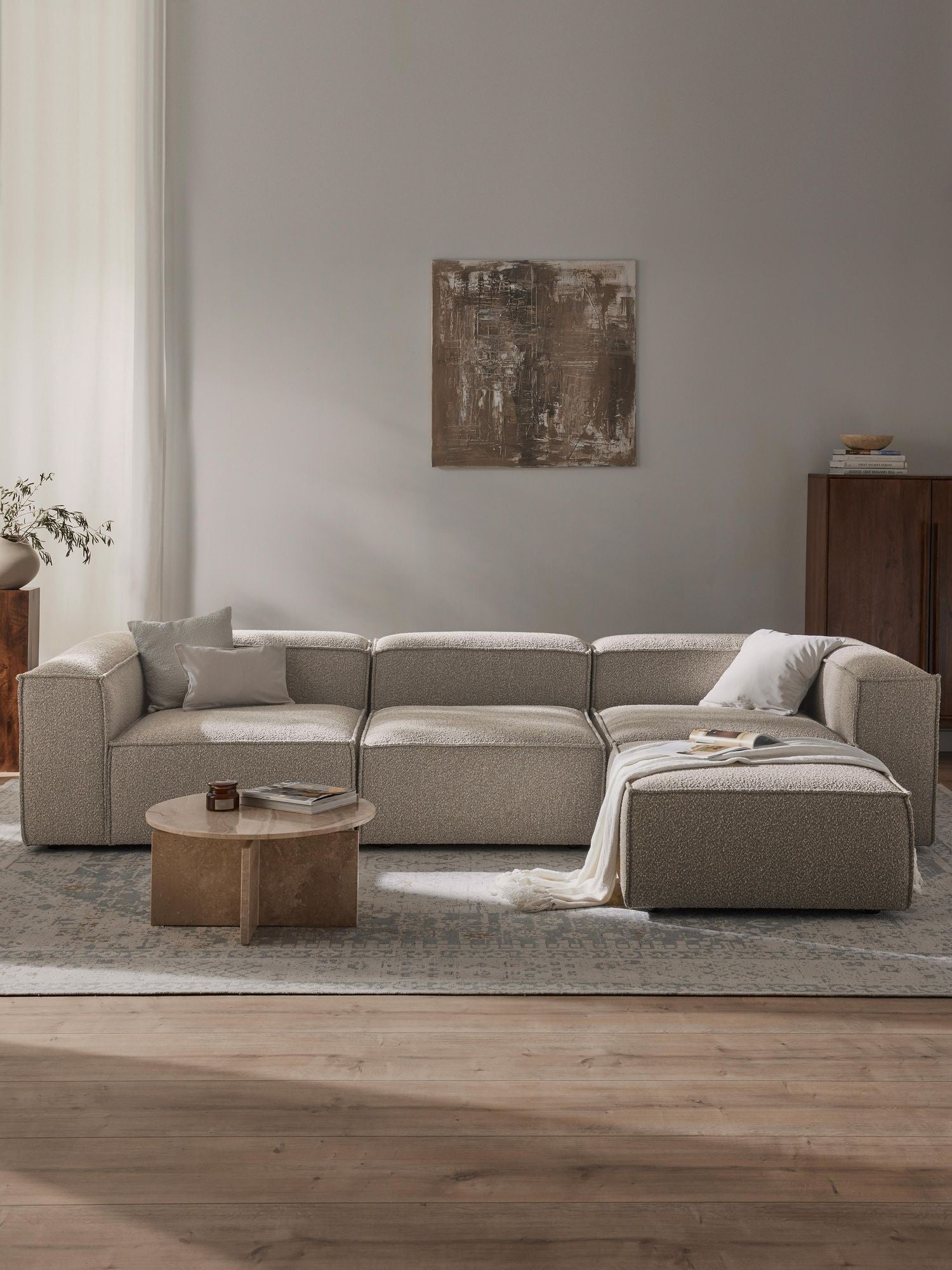 Canapé modulable 4 places en tissu bouclé avec pouf Frida